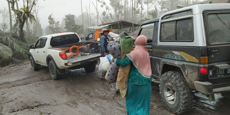 Sejumlah warga Desa Supiturang membawa harta bendanya yang masih bisa diselamatkan. Mereka memilih tetap mengungsi meski dihantui ancaman penjarahan. Foto: Ulul Azmy