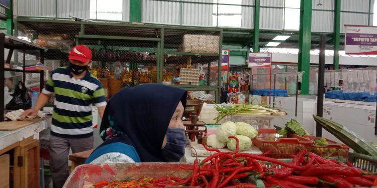 Isnaini, pedagang cabai dan sayur di Pasar Klojen Kota Malang menanti pembelinya