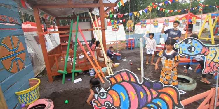 Anak-anak pengungsi bermain riang di Taman Bermain Kumpul Bocah Semeru di lapangan Desa Penanggal. Foto: Loah Mahfud