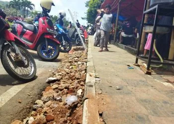 PKL tutup selokan dengan urukan material kerikil