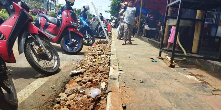 PKL tutup selokan dengan urukan material kerikil