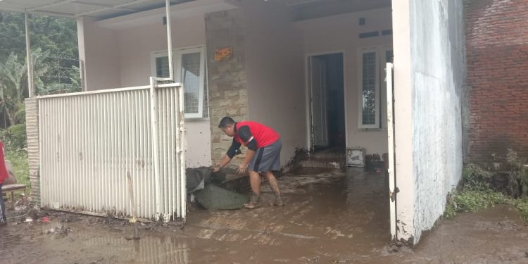 Relawan dan warga Kota Malang membersihkan rumah usai dilanda banjir. Foto: M Sholeh