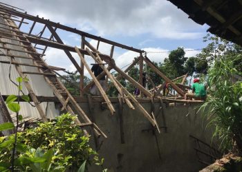 Para tukang memperbaiki atap rumah yang rusak akibat hujan. Foto/Pusdalops BPBD Kota Batu