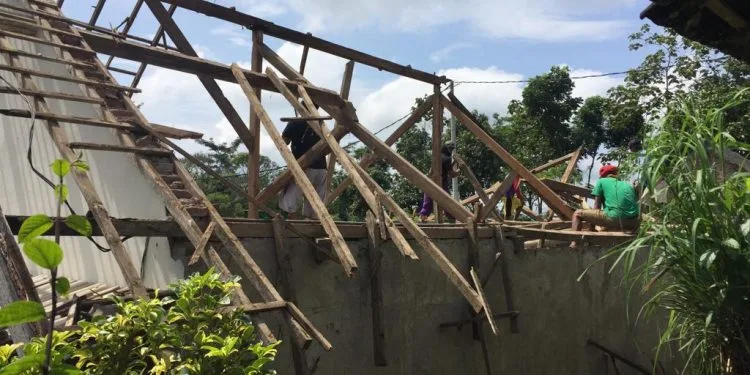 Para tukang memperbaiki atap rumah yang rusak akibat hujan. Foto/Pusdalops BPBD Kota Batu