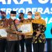 Bupati Malang Sanusi saat menerima penghargaan dari Gubernur Jatim