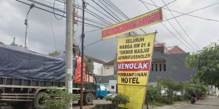 Spanduk penolakan warga yang dibentangkan di sekitar lokasi rencana pembangunan hotel (M Sholeh)