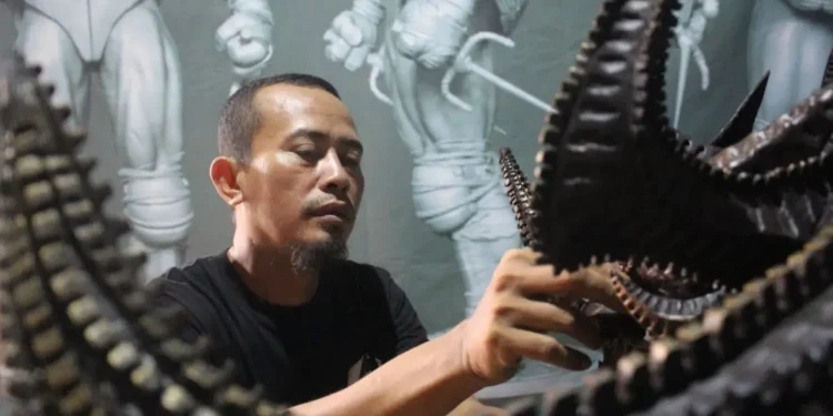 Fitrah Firmansyah mengerjakan pemesanan kostum.