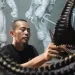 Fitrah Firmansyah mengerjakan pemesanan kostum.