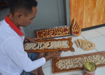 Cak Nardi, napi atau warga binaan Lapas Kelas I Malang membuat kerajinan kaligrafi ukiran.