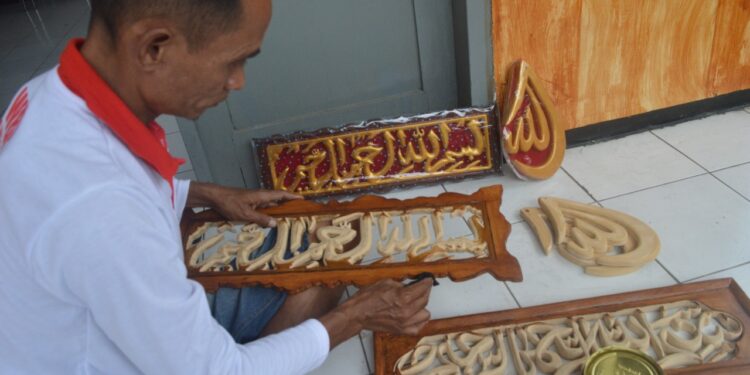 Cak Nardi, napi atau warga binaan Lapas Kelas I Malang membuat kerajinan kaligrafi ukiran.