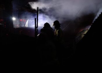 Petugas melakukan pemadaman api di Pasar Loak Singosari.