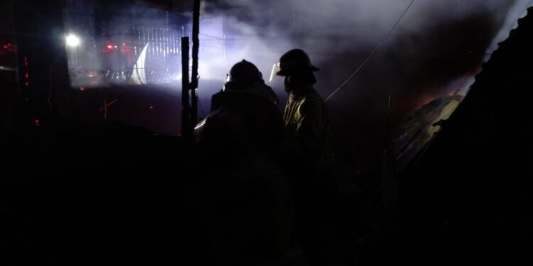 Petugas melakukan pemadaman api di Pasar Loak Singosari.
