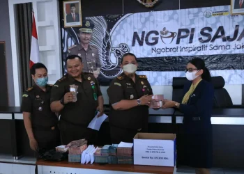 Serah terima uang wajib pajak dari Kejari Kota Batu sebagai bukti dalam ungkap kasus penyimpangan pungutan daerah yang melibatkan staf PNS di lingkup Bapenda Kota Batu, Selasa (27/9/2022).
