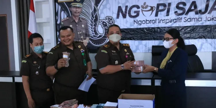 Serah terima uang wajib pajak dari Kejari Kota Batu sebagai bukti dalam ungkap kasus penyimpangan pungutan daerah yang melibatkan staf PNS di lingkup Bapenda Kota Batu, Selasa (27/9/2022).