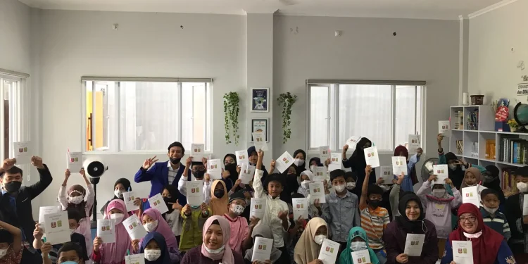 Tim Pengabdian UM membagikan buku saku untuk peserta didik. foto dok. LLPM UM.