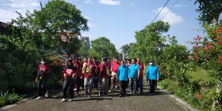 Jajaran rektorat, yayasan dan mahasiswa tengah berjalan menuju beberapa titik penanaman pohon.
