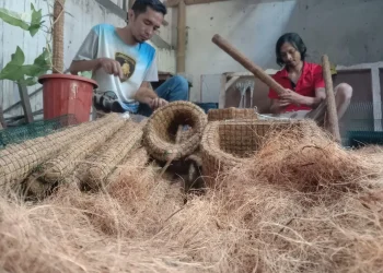 Seto Sutrioko (baju merah) bersama rekannya membuat berbagai produk media tanaman hias dari sabut kelapa.