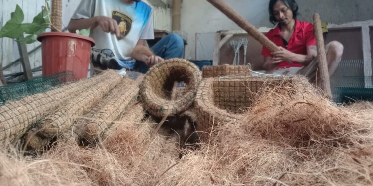 Seto Sutrioko (baju merah) bersama rekannya membuat berbagai produk media tanaman hias dari sabut kelapa.