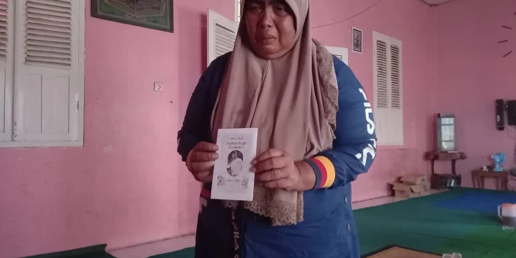 Tuwin menunjukkan amplop yang akan digunakan untuk membagi-bagikan sedekah.