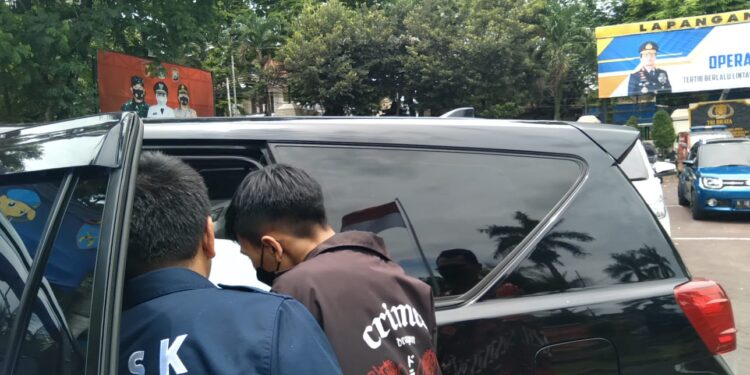 Pengunggah video (jaket coklat) usai memberikan keterangan di Polres Malang.