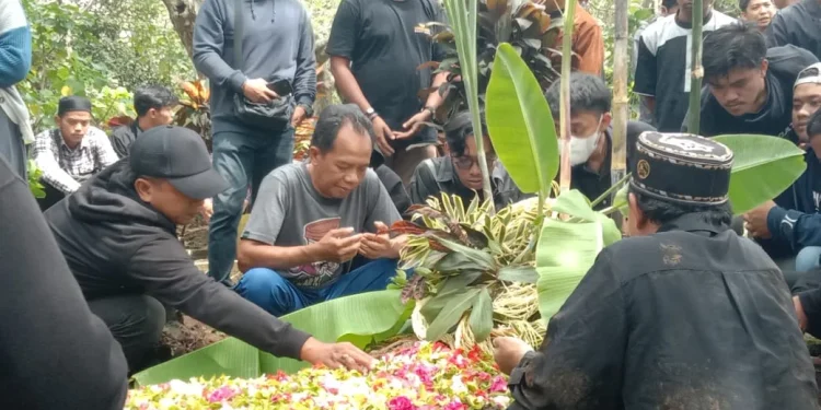 Kerabat dan pelayat berdoa di pusara korban Tragedi Kanjuruhan.