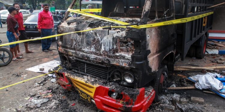 Bangkai kendaraan milik aparat yang dibakar oleh suporter Arema di sekitar Stadion Kanjuruhan, Kabupaten Malang. Foto/Bayu Eka Novanta