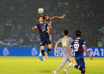 Pemain Arema FC Renshi Yamaguchi berduel dengan pemain Persebaya Surabaya dalam laga lanjutan BRI Liga 1 di Stadion Kanjuruhan, Kabupaten Malang, Minggu (01/10/2022).