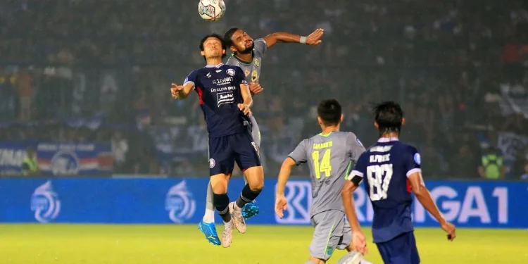 Pemain Arema FC Renshi Yamaguchi berduel dengan pemain Persebaya Surabaya dalam laga lanjutan BRI Liga 1 di Stadion Kanjuruhan, Kabupaten Malang, Minggu (01/10/2022).