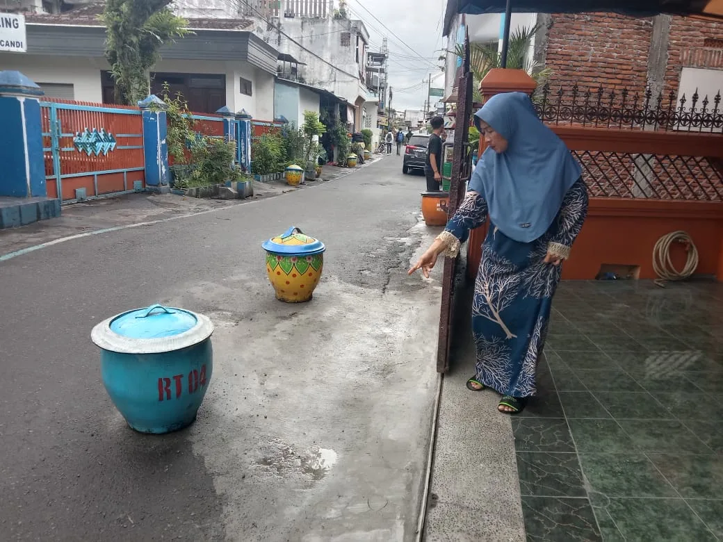 Warga Kelurahan Pisang Candi menunjukkan lokasi jalan yang ambles dan kerusakan akibat dilintasi alat berat pembangunan gorong gorong.