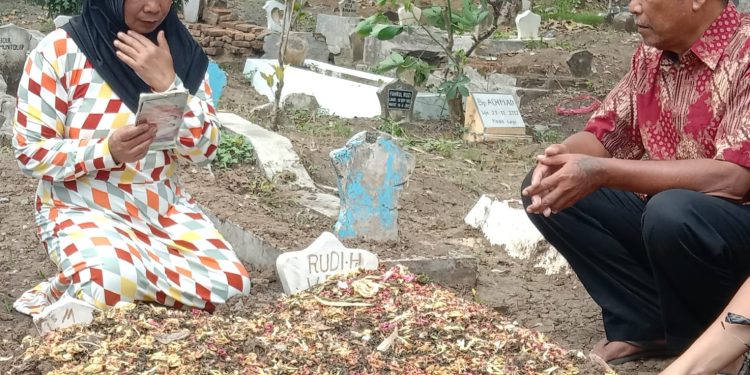 Agus Suhartono meratapi makam menantu dan cucunya yang gugur dalam tragedi Stadion Kanjuruhan.
