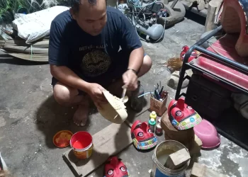 Wahid, saat mengerjakan topeng malangan di studio seni miliknya.