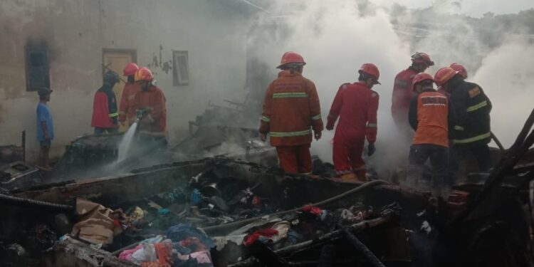 Petugas melakukan pemadaman sisa sisa api yang membakar rumah kontrakan di Kota Malang.