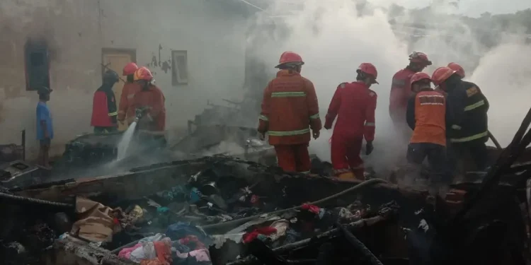 Petugas melakukan pemadaman sisa sisa api yang membakar rumah kontrakan di Kota Malang.