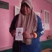 Winartiningsih memegang amplop dengan foto mendiang anaknya.