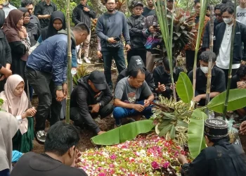 Keluarga, kerabat dan pelayat melantunkan doa di tempat peristirahatan terakhir korban Tragedi Kanjuruhan.