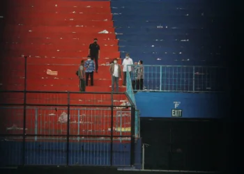 Beberepa Aremania memberi penghormatan terakhir di Stadion Kanjuruhan.