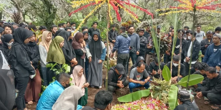 Keluarga, kerabat dan pelayat melantunkan doa di tempat peristirahatan terakhir korban Tragedi Kanjuruhan.