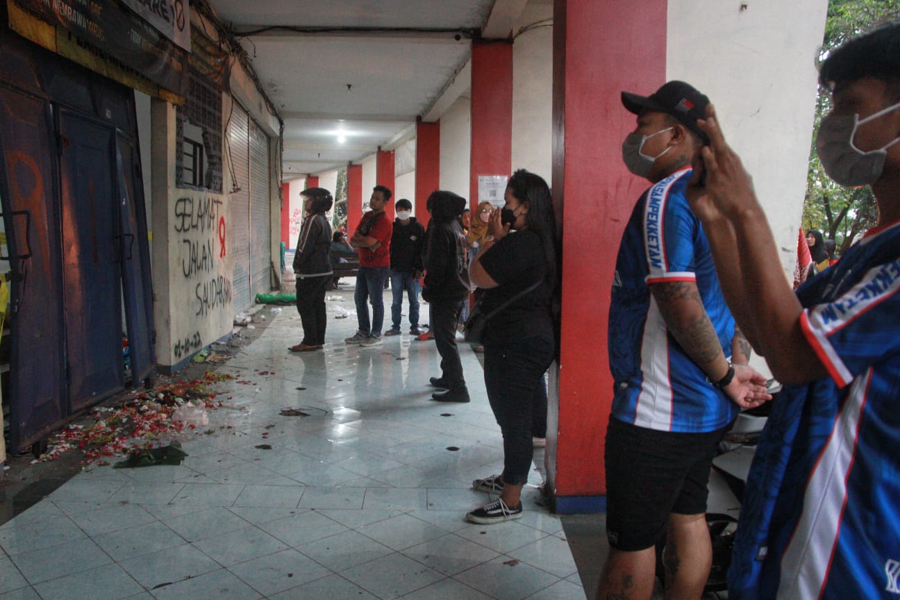 Beberapa Aremania menabur bunga di Gate 13 di Stadion Kanjuruhan, Kabupaten Malang, yang menjadi lokasi jauhnya para korban.