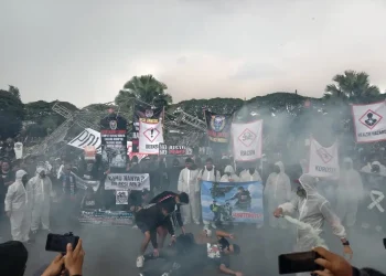 Teatrikal penembakan gas air mata oleh aparat dalam aksi 40 hari Tragedi Kanjuruhan.
