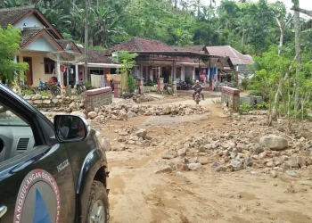 Material tanah longsor menutupi akses jalan desa.