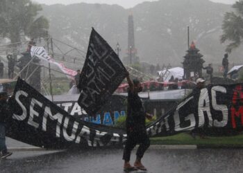 Aremanaia tetap menggelar aksi menuntut keadilan korban Tragedi Kanjuruhan meski diguyur hujan deras.