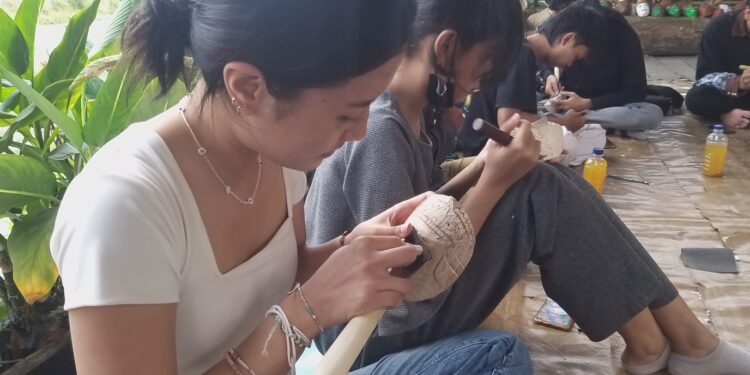 Mahasiwa seni rupa Universitas Brawijaya belajar membuat topeng malang di di Kampung Budaya Polowijen.