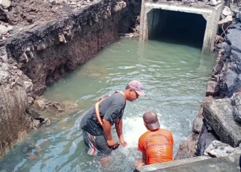 Petugas melakukan perbaikan pipa PDAM yang jebol di Jalan Veteran, Kota Malang.