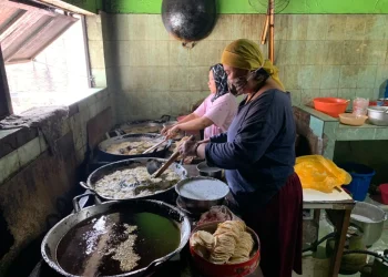 Dua orang pekerja perempuan sedang menggoreng keripik tempe, senin (21/11/2022).