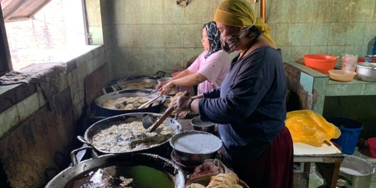 Dua orang pekerja perempuan sedang menggoreng keripik tempe, senin (21/11/2022).