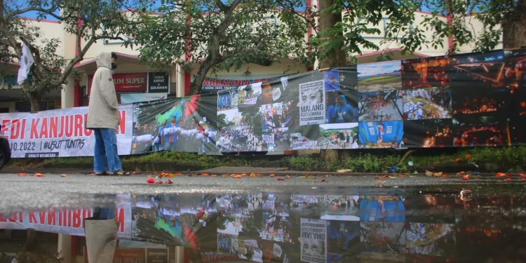 Jurnalis Malang Raya membentangkan spanduk sepanjang 37 meter berisi rangkaian foto bercerita tentang Tragedi Kanjuruhan di depan Balai Kota Malang, Kamis (10/11/2022).