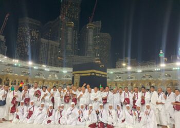 Jamaah umrah POS IV foto bersama di Masjidil Haram Mekkah, Arab Saudi dengan latar belakang Kakbah.