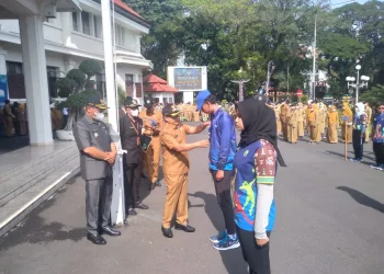 Wali Kota Malang Sutiaji saat mengenakan jaket dan topi secara simbolis kepada atlet Popda XIII.