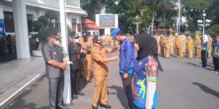 Wali Kota Malang Sutiaji saat mengenakan jaket dan topi secara simbolis kepada atlet Popda XIII.