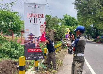 Petugas Satpol PP Kota Batu tengah menertibkan sejumlah reklame ilegal di jalan-jalan.